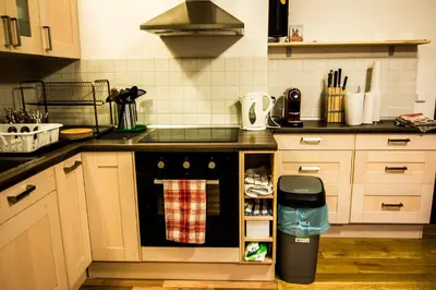 a kitchen with a black oven with a trash can at Onefam Míru in Prague