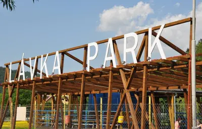a sign for a park on top of a wooden structure at Lávka Park Skochovice in Vrané nad Vltavou