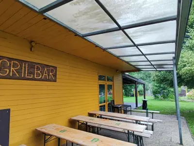 a patio with wooden tables and benches in a building at Lávka Park Skochovice in Vrané nad Vltavou