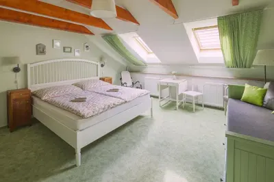 a bedroom with a large bed and a table at Zelený statek in Bzová