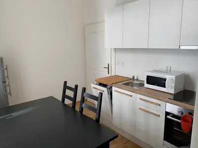 a kitchen with white cabinets and a table and a microwave at OLD TOWN SPIRIT in Prague