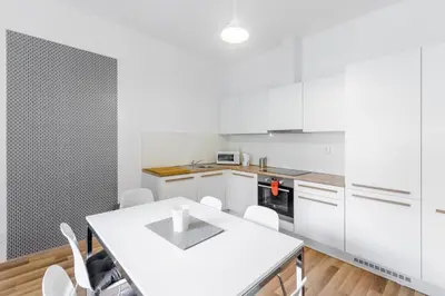 a kitchen with white cabinets and a white table and chairs at OLD TOWN SPIRIT in Prague