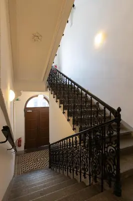 a staircase with a black railing and a wooden door at OLD TOWN SPIRIT in Prague