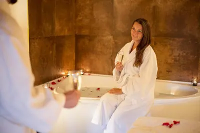 a woman sitting on a bath tub in a bathroom at Pytloun Chateau Hotel Ctěnice in Prague