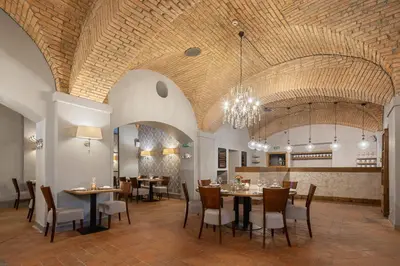 a dining room with tables and chairs and a chandelier at Pytloun Chateau Hotel Ctěnice in Prague