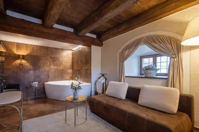 a living room with a couch and a tub at Pytloun Chateau Hotel Ctěnice in Prague