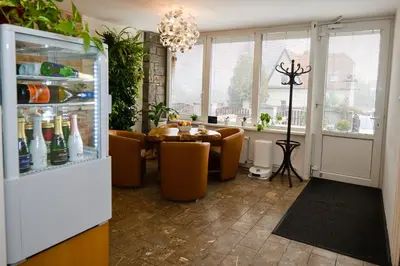 a dining room with a table and chairs and a refrigerator at Wellness Vila Bohemia in Prague