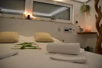 a white bed with towels on it with a window at Wellness Vila Bohemia in Prague
