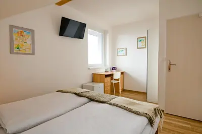 a bedroom with two beds and a television on the wall at Wellness Vila Bohemia in Prague