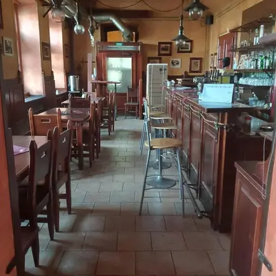 a restaurant with tables and chairs and a bar at Pension Kozel in Ricany