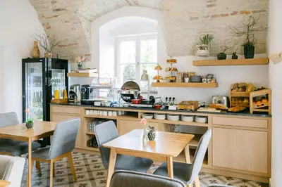 a kitchen with wooden tables and chairs and a counter at Na Kmíně in Obříství