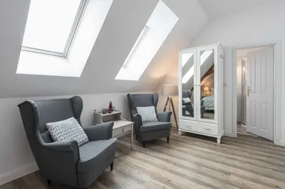 a living room with two chairs and a mirror at Na Kmíně in Obříství