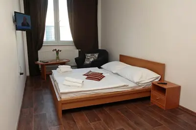 a bedroom with a bed and a chair and a window at Hotel Arko in Prague