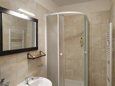 a bathroom with a shower and a sink and a mirror at Hotel Arko in Prague