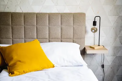 a bed with a yellow pillow and a lamp at Hotel Arko in Prague