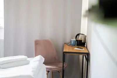 a room with a chair and a table with a coffee maker at Hotel Arko in Prague
