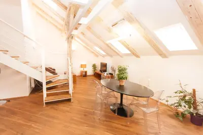 a room with a table and chairs and a staircase at Kozna Loft in Prague