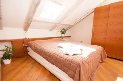 a bedroom with a bed in a room with a window at Kozna Loft in Prague