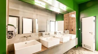 a bathroom with three sinks and a row of mirrors at Czech Inn in Prague
