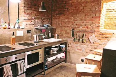 a kitchen with a sink and a brick wall at Czech Inn in Prague