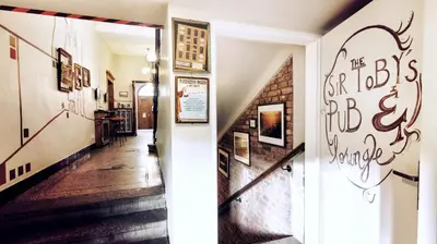 a hallway with stairs and a sign that reads the boston bicycle garage at Sir Toby's Hostel in Prague