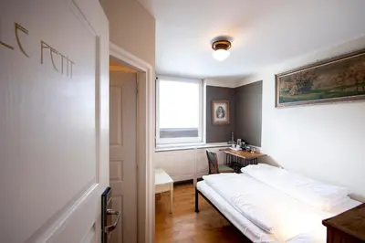 a room with a bed and a table and a window at Sir Toby's Hostel in Prague