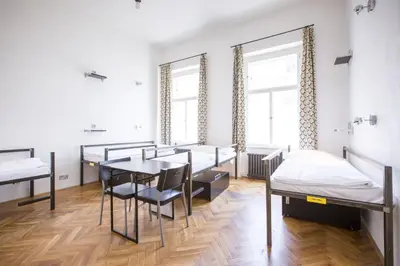 a room with beds and a table and chairs at Sophie's Hostel in Prague