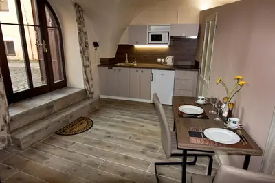 a small kitchen with a wooden table and a table and chairs at Apartmán U Gotického dvojčete in Litoměřice
