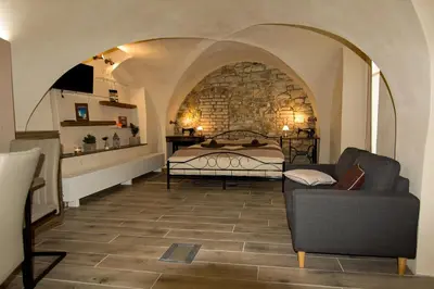 a bedroom with a bed and a couch in a room at Apartmán U Gotického dvojčete in Litoměřice