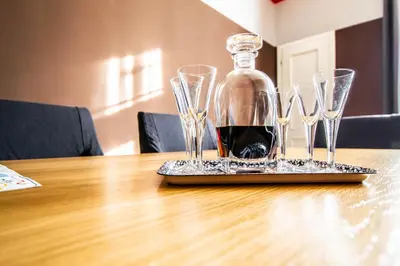 a bottle of wine and four wine glasses on a table at Garden Apartments in Prague