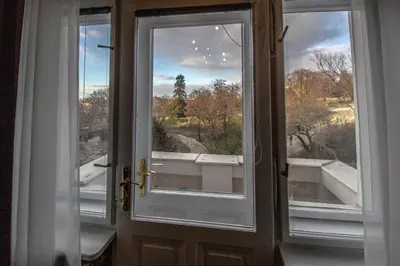 an open door with two windows and a view at Garden Apartments in Prague