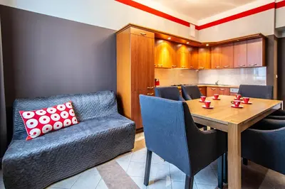 a dining room with a table and a kitchen at Garden Apartments in Prague