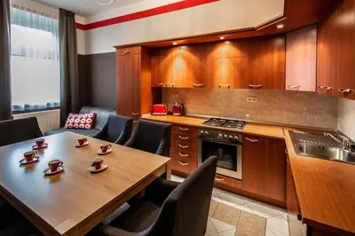 a kitchen with a wooden table and chairs and a counter at Garden Apartments in Prague