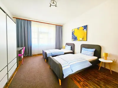 a hotel room with two beds and a desk at Václavkova Apartment in Mladá Boleslav