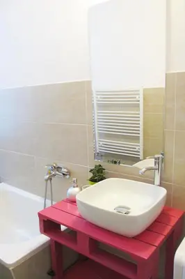 a bathroom with a white sink on a red table at Václavkova Apartment in Mladá Boleslav