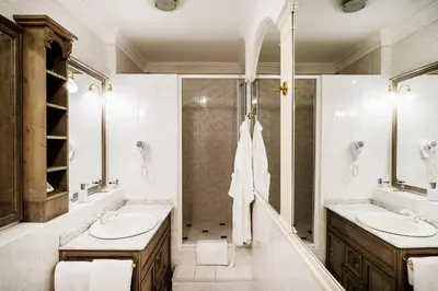 a bathroom with two sinks and a shower at Nebozizek Hotel a Restaurant in Prague