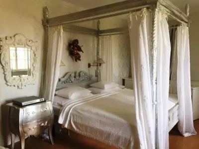 a bedroom with a large white bed with curtains at Nebozizek Hotel a Restaurant in Prague