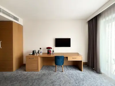 a hotel room with a desk and a tv at GAZDA Hotel&Restaurant - Self Chek-In in Jesenice