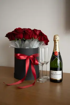 a bottle of champagne and a glass of wine and roses at GAZDA Hotel&Restaurant - Self Chek-In in Jesenice