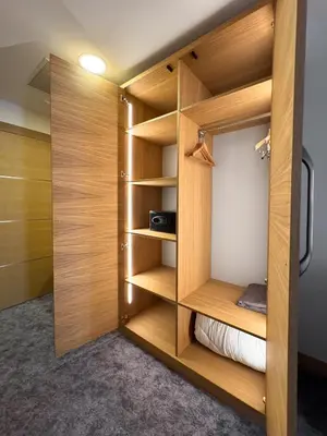 a walk in closet with wooden dividers in a room at GAZDA Hotel&Restaurant - Self Chek-In in Jesenice