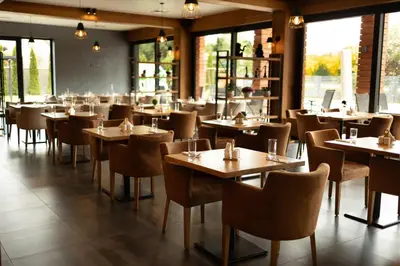 a restaurant with wooden tables and chairs and windows at GAZDA Hotel&Restaurant - Self Chek-In in Jesenice