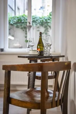 a table with a bottle of wine and two glasses at Quiet apartment in the city center with own terrace in Prague