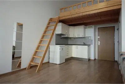 a loft bed in a room with a kitchen at Karlín Praha - Pernerova 18 in Prague
