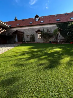 a large yard with a house with a large shadow at Penzion u Svatého Prokopa in Středokluky