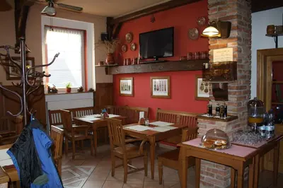 a restaurant with wooden tables and chairs in a room at Hotel Bouček in Mochov