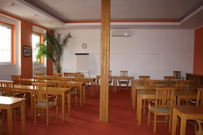 an empty classroom with wooden tables and chairs at Hotel Bouček in Mochov