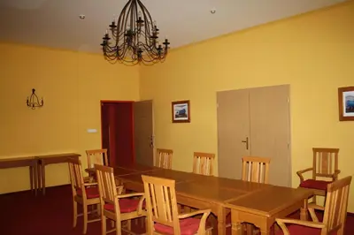 a dining room with a wooden table and chairs at Hotel Bouček in Mochov
