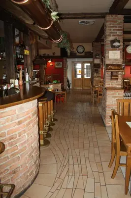 a bar in a restaurant with a brick wall at Hotel Bouček in Mochov