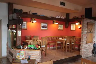 a dining room with red walls and a table and chairs at Hotel Bouček in Mochov