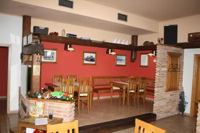 a dining room with red walls and wooden tables and chairs at Hotel Bouček in Mochov
